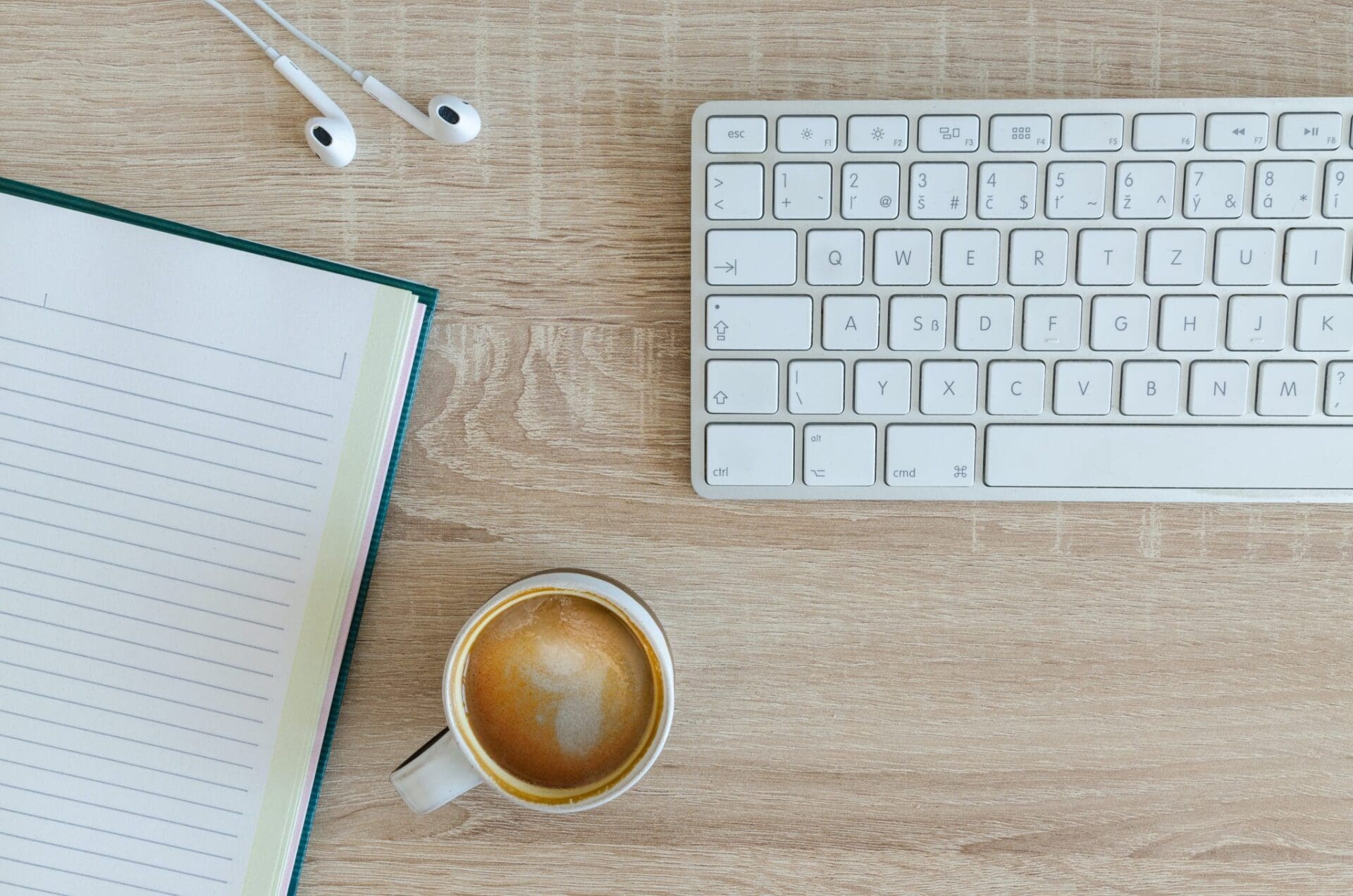 coffee and notebook with keyboard and headphones used for blogging and content creating that helps with digital marketing in nashville